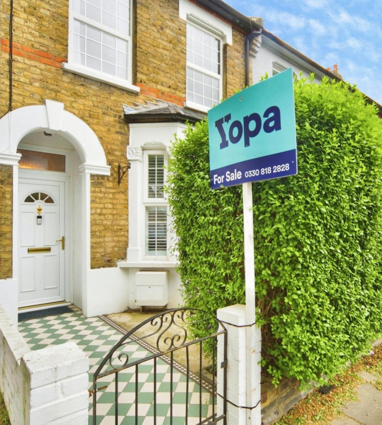 Residential street with a property For Sale sign