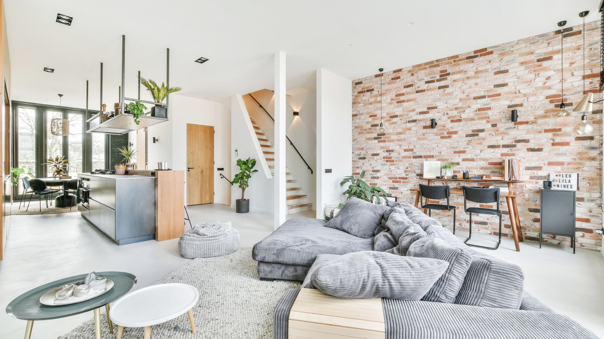 Modern open-plan loft with exposed brick wall and corduroy sofa